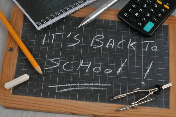 Back to school written on a school slate with school supplies