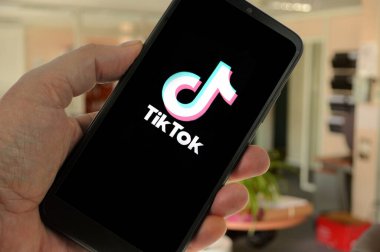 TikTok app on smartphone held in hand close up 