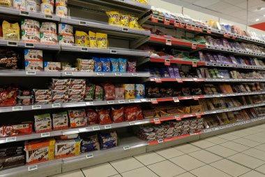 Shelves of different confectionery and chocolate brands of a french supermarket 