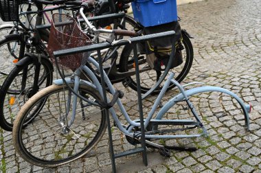 Padlocked bicycle with stolen wheel and saddle 