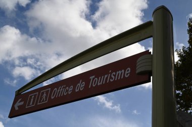 Yol tabelası Fransızca turizm bürosunu gösteriyor.