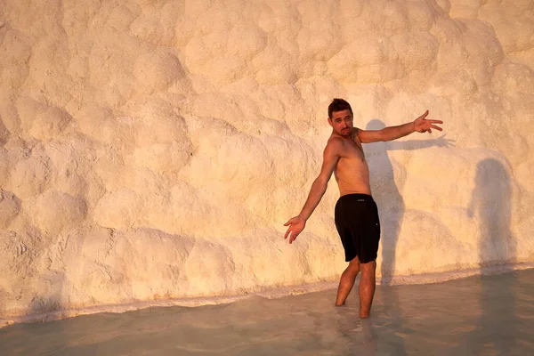 Pamukkale Doğal Parkı 'nda Türkiye' de beyaz travertin arasında yüzen mutlu bir gezgin. Genç adam Pamukkale doğal parkında güzel manzaralı bir havuzda dinleniyor..                      