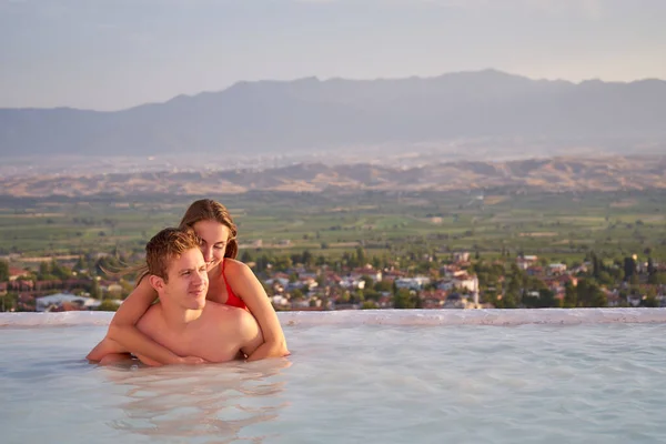 新婚旅行でパムッカレのプールでの愛の水泳のカップル バレンタインデーのコンセプト 美しい夕日を楽しむ恋人 — ストック写真