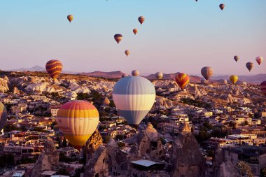 Goreme, Kapadokya, Türkiye-08 Ağustos 2020 Sıcak hava balonları bir dağ Kapadokya Goreme Ulusal Parkı hindisine indi. Gündoğumunda uçan renkli sıcak hava balonu..                                   