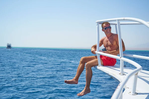 Photo of handsome happy attractive man outdoors posing on yacht in Red sea.enjoys crew duty, luxury holidays, yachting sport activities, sailing the oceans, summer vacation and recreation