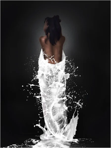 Menina morena com salpicos de leite no fundo preto — Fotografia de Stock
