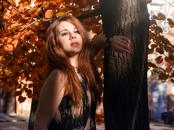 Menina com cabelo vermelho ficar perto da árvore — Fotografia de Stock