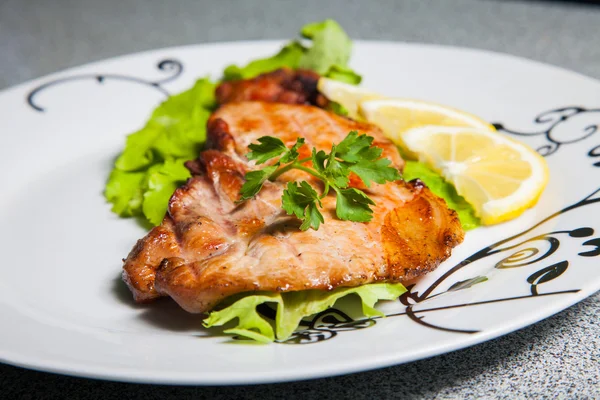 Portion of grilled meat on a plate with a pattern — Stock Photo, Image