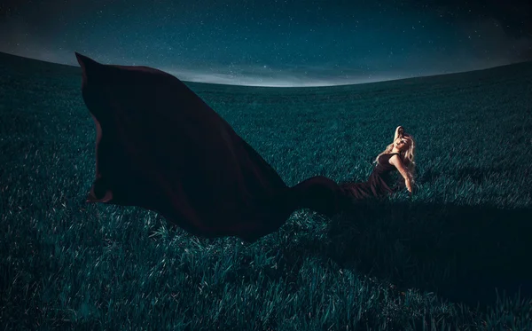 Симпатичная девушка, лежащая в поле — стоковое фото