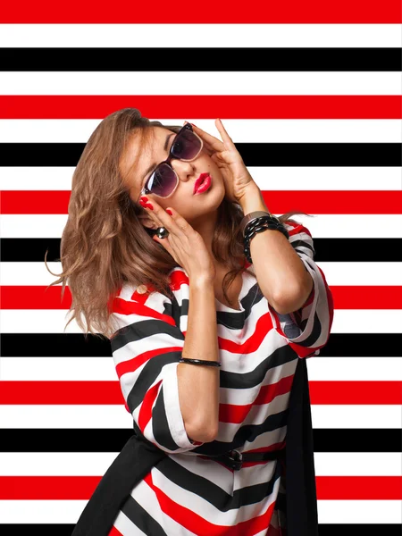 Giovane donna in occhiali da sole su sfondo strisce — Foto Stock