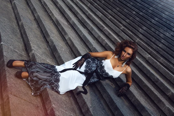 Wunderbare Frau mit braunen Haaren liegt auf der Treppe — Stockfoto