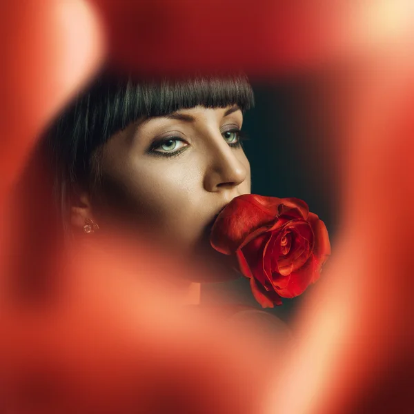 Female looking away beahind red roses — Stock Photo, Image