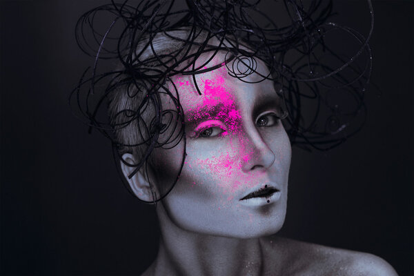 Сексуальная взрослая женщина с неоновым порошком на лице
