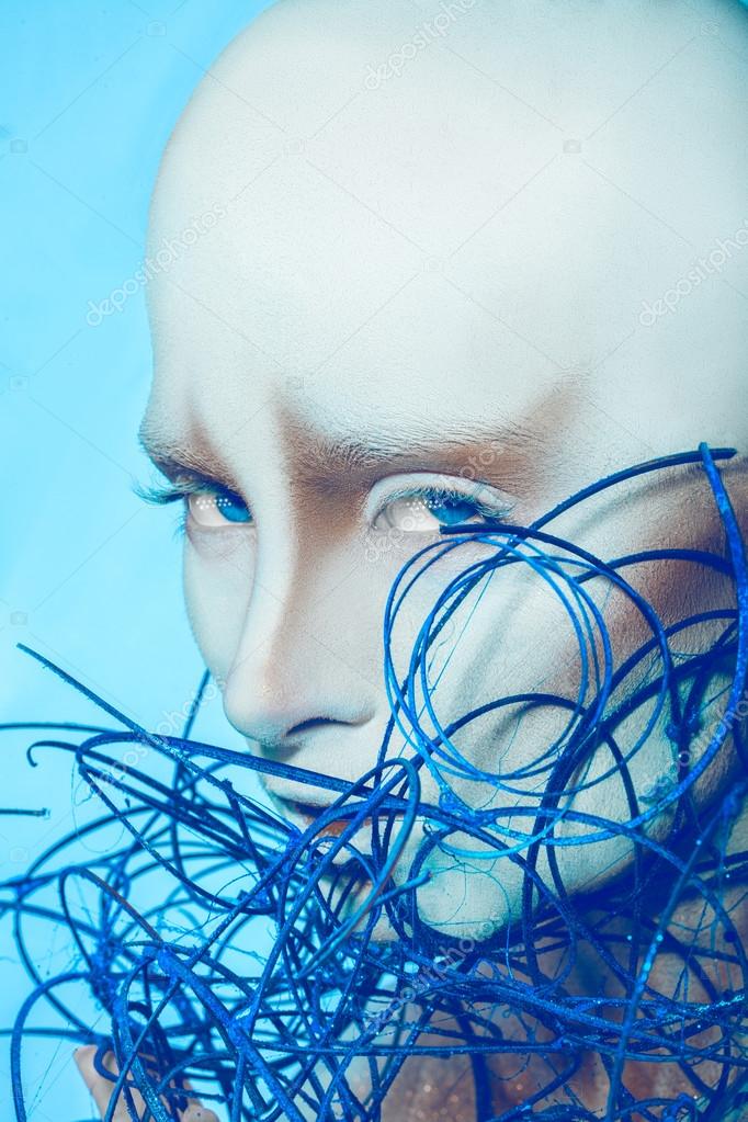 Attractive bald woman with body art on blue background