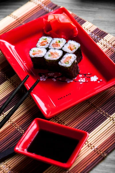 Rolo japonês com salmão em prato vermelho — Fotografia de Stock