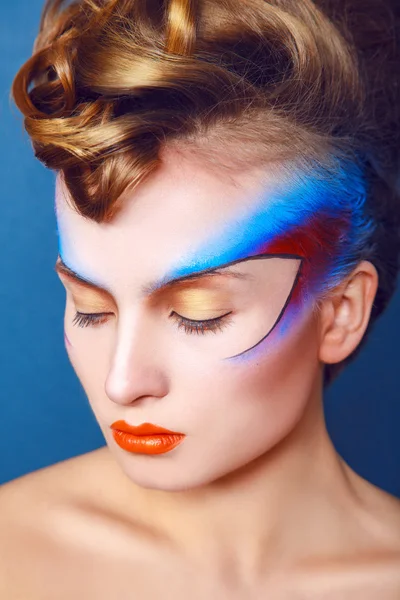Vrouw met creatieve make-up en haarstijl op blauwe achtergrond — Stockfoto