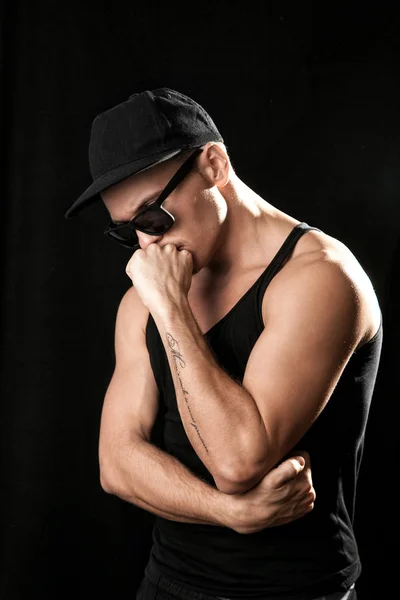 Strong muscular man in sunglasses on black background — Stock Photo, Image