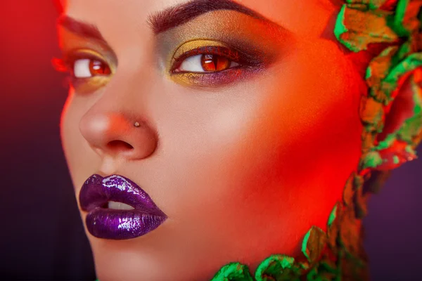 Kırmızı ışıklarda yaratıcı makyaj ile şehvetli kız