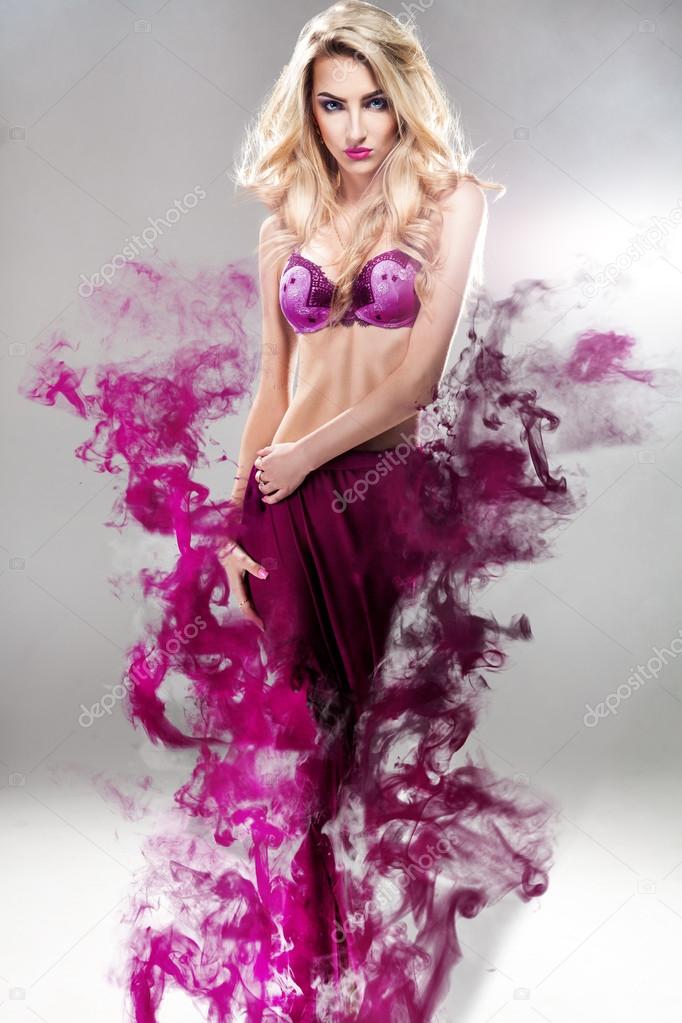 Beautiful blonde fashion model with dress in smoke