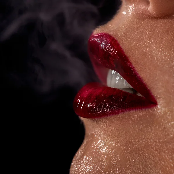 宏的湿的女人的嘴唇与烟气在背景上的照片 — 图库照片