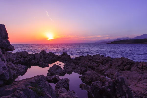 Övergripande bild av solnedgång på stenig strand — Stockfoto
