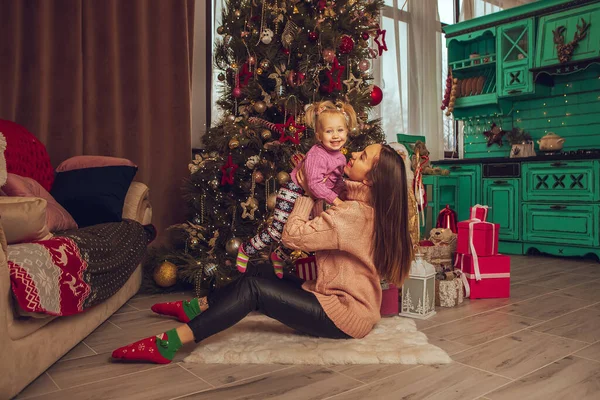 Bella Giovane Madre Abbraccia Sua Bambina All Albero Natale — Foto Stock