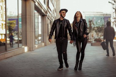 Mutlu genç çift sokakta yürüyor ve gülüyor.