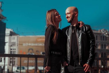 Gündüz vakti sokakta poz veren neşeli genç bir çiftin portresi.