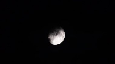 Full moon, clouds move in front of the moon and hide the whole.