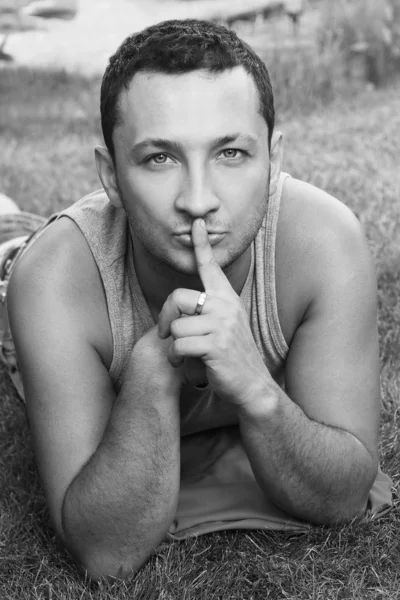 Man holding a finger to his mouth — Stock Photo, Image