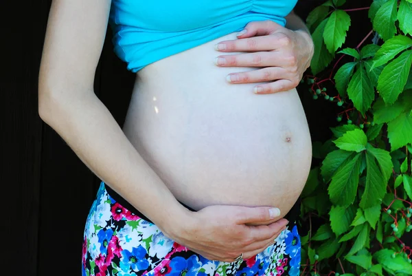 Jonge zwangere vrouw ontspannen bij een park — Stockfoto