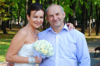 Bride posing for the camera with her father clipart
