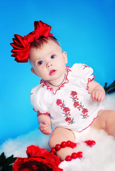 Little child with red bow, flowers and necklace — Stock Photo, Image