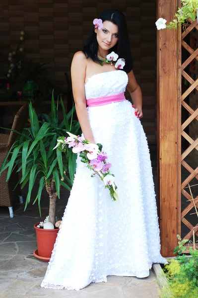 Mujer joven en vestido blanco con flor — Foto de Stock