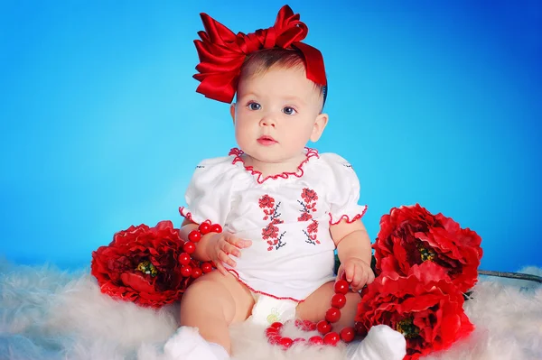 Kleines Kind mit roter Schleife, Blumen und Halskette — Stockfoto