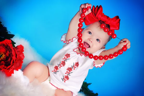 Little child with red bow, flowers and necklace — Stock Photo, Image