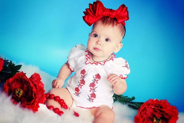 Klein kind met rode boog, bloemen en ketting — Stockfoto
