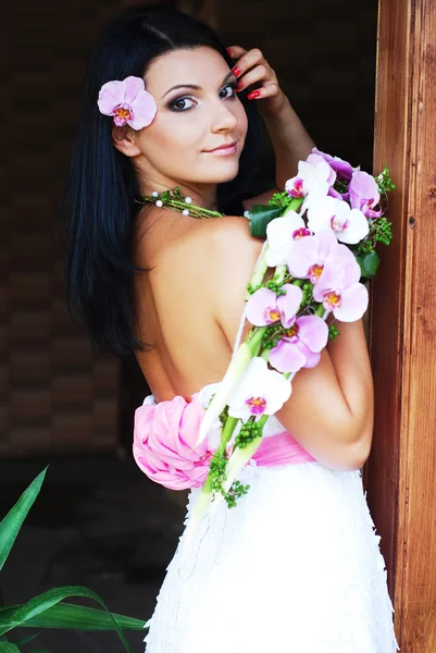 Mujer joven en vestido blanco con flor — Foto de Stock