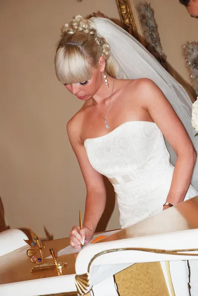 Young attractive bride signing wedding certificates — Stock Photo, Image