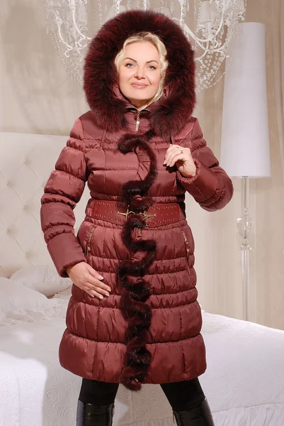 Mooie blonde vrouw in winterjas met kap — Stockfoto