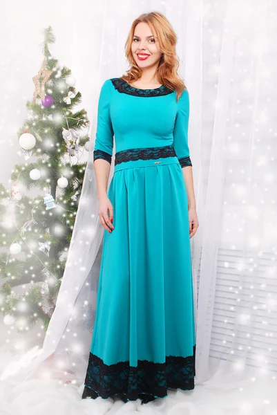 Young woman standing in front of christmas tree — Stock Photo, Image
