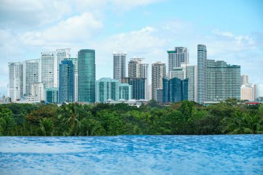 Üst kattaki havuzdan Manila şehrinin gökdelenlerinin manzarası. Turistler olmadan boş havuz.