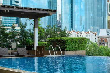 Manila, Filipinler - Şubat 02, 2020. Manila şehrinin beş yıldızlı lüks Discovery Primea otelinin havuzundan görünüşü. Güneşli bir hava. Arka planda gökdelenler.