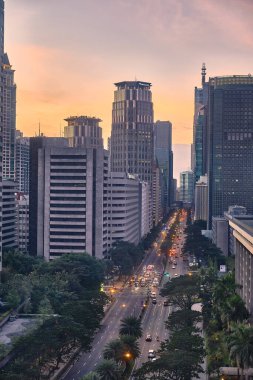 Manila, Filipinler - Şubat 01, 2020: Makati şehrinin akşam manzarası. Gökdelenler parlak batan güneşe karşı.