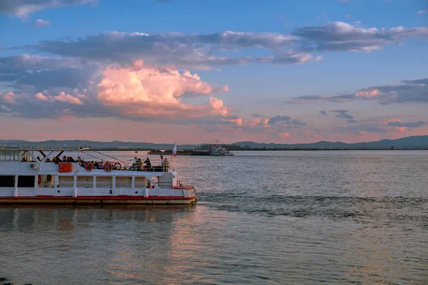 Khabarovsk, Russie - 29 sept. 2021 : Coucher de soleil sur le remblai de l'Amour à Khabarovsk. Un bateau de plaisance navigue sur la rivière. Le niveau de l'Amour à environ 364 centimètres. — Photo