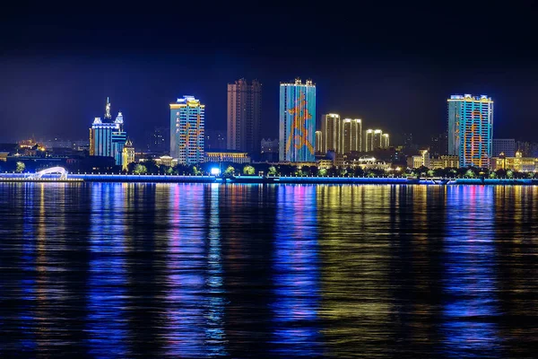 Blagoveshchensk, Rosja - październik 07, 2020: widok na chińskie miasto Heihe z nasypu miasta Blagoveshchensk. Światła nocnego miasta w odbiciu rzeki Amur. — Zdjęcie stockowe