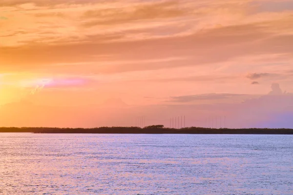 Puesta de sol en el terraplén del río Amur en Jabárovsk. Puesta de sol sobre el horizonte. Hojas de árboles de otoño en el fondo. —  Fotos de Stock