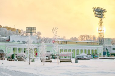 Culture and Recreation Park of Khabarovsk, Russia after heavy snowfall in the morning at sunrise. Trees in the snow. Lenin Football Stadium.