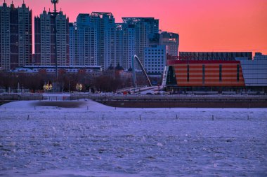 BLAGOVESHCHENSK, Rusya - Şubat 01, 2021: Blagoveshchensk seti üzerinden Çin 'in Heihe kentinin manzarası. Amur Nehri buzun altında.