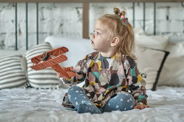 꼬리달린 귀엽고 소녀가 장난감 비행기를 가지고 있습니다 — 스톡 사진
